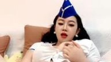 Mature woman in a revealing flight attendant outfit, fully visible face, wearing white stockings, flirting and interacting with fans, featuring close-ups of breast rubbing and explicit sexual acts, including moaning and suggestive dialogue, part 2